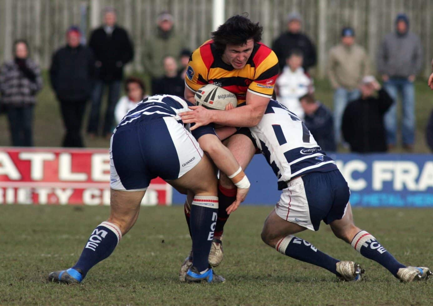 2010 - Dewsbury v Featherstone - Rams Luke Blake driving forward Andy Kain Rgt